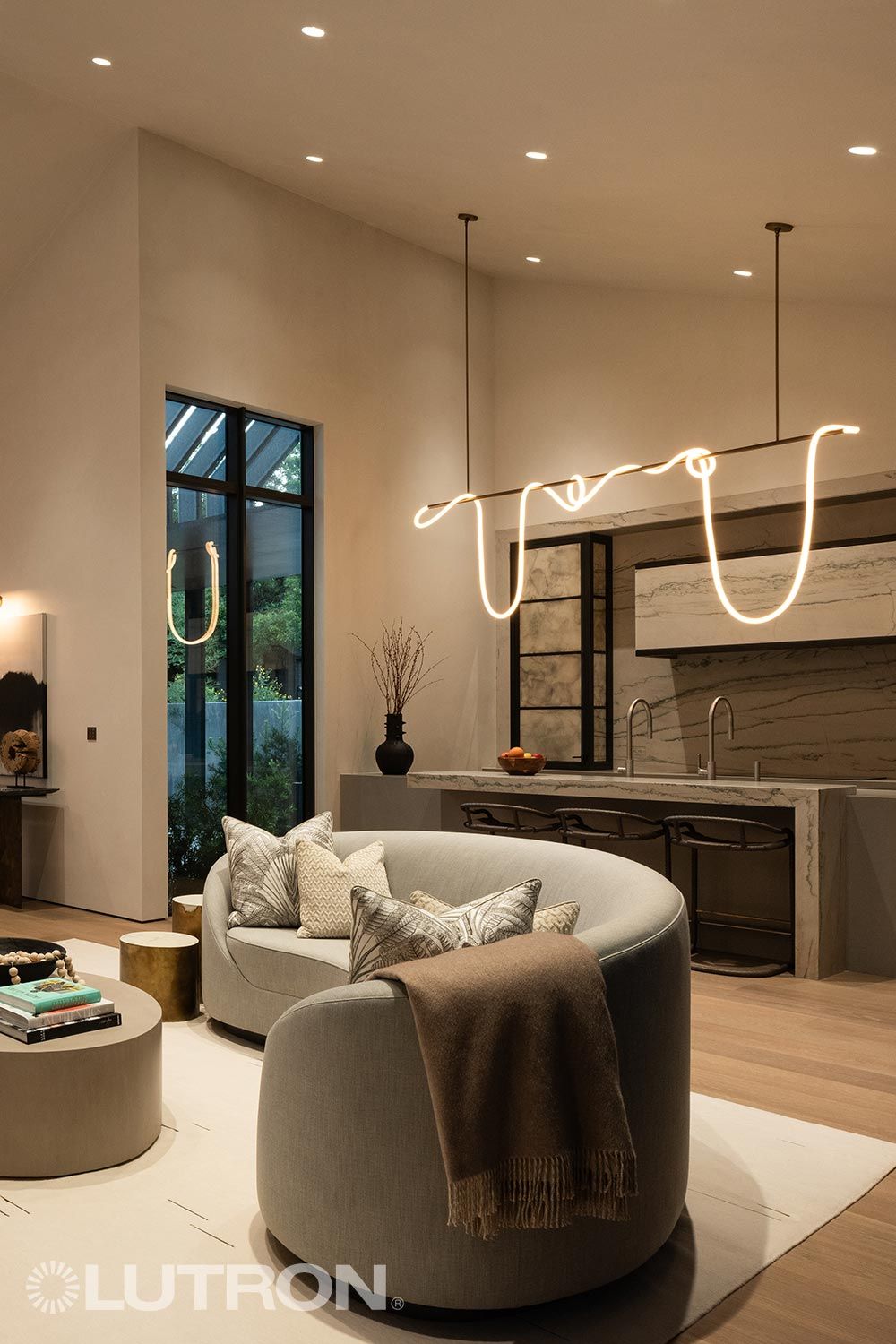 Modern living space with unique pendant lights and Lutron branding