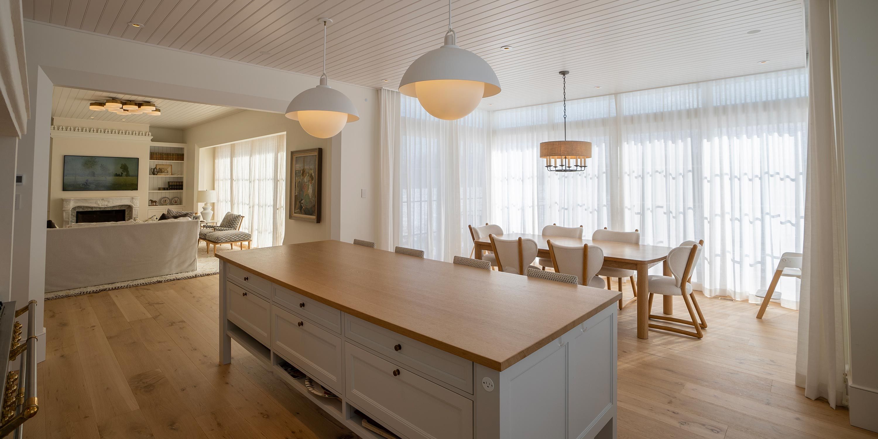 Modern kitchen with a large island, pendant lighting, and open seating area, combining warmth and functionality.